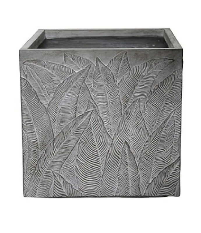 06100000035-1.jpg Maceta cuadrada de fibra de arcilla en color gris con relieves decorativos de hojas grandes cubriendo toda la superficie.