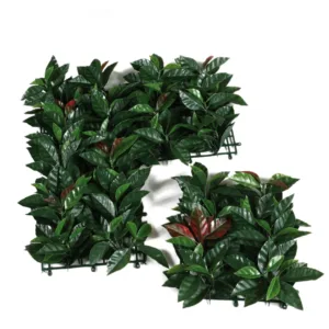 Cuatro losetas de 50x50 cm del Jardín Vertical Liptus instaladas en una pared, formando un panel de 1x1 metro de follaje artificial tipo eucalipto en un ambiente moderno de interior.